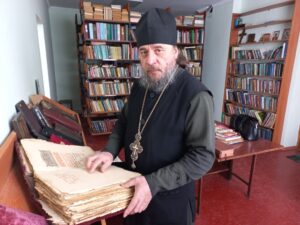 В руках у отца Виктора книга, которой более 200 лет
